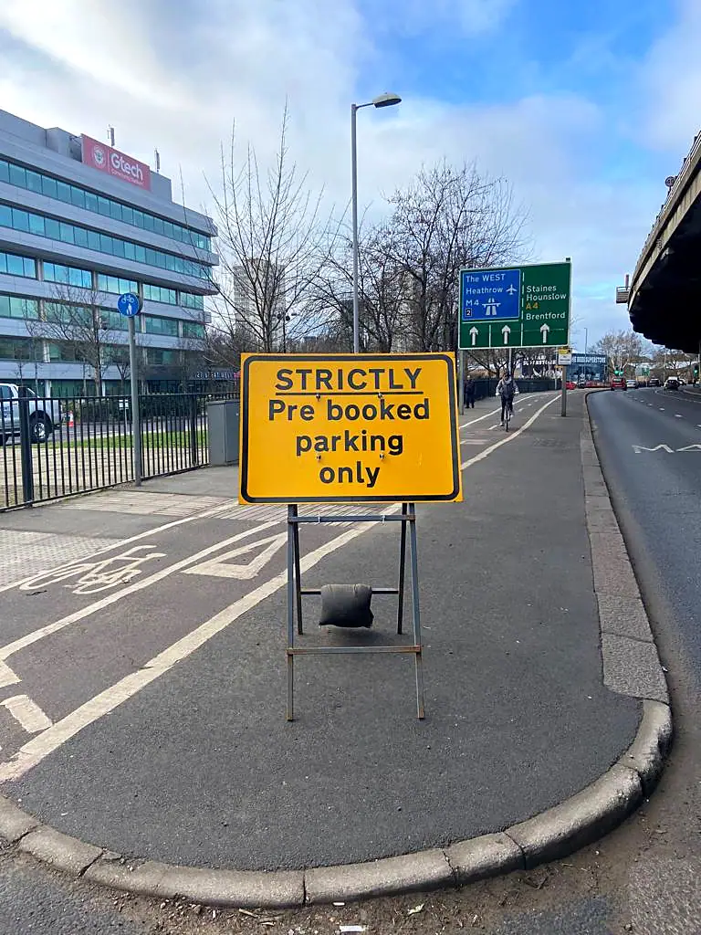 A Strictly Pre-booked Parking Only sign on a city roadside